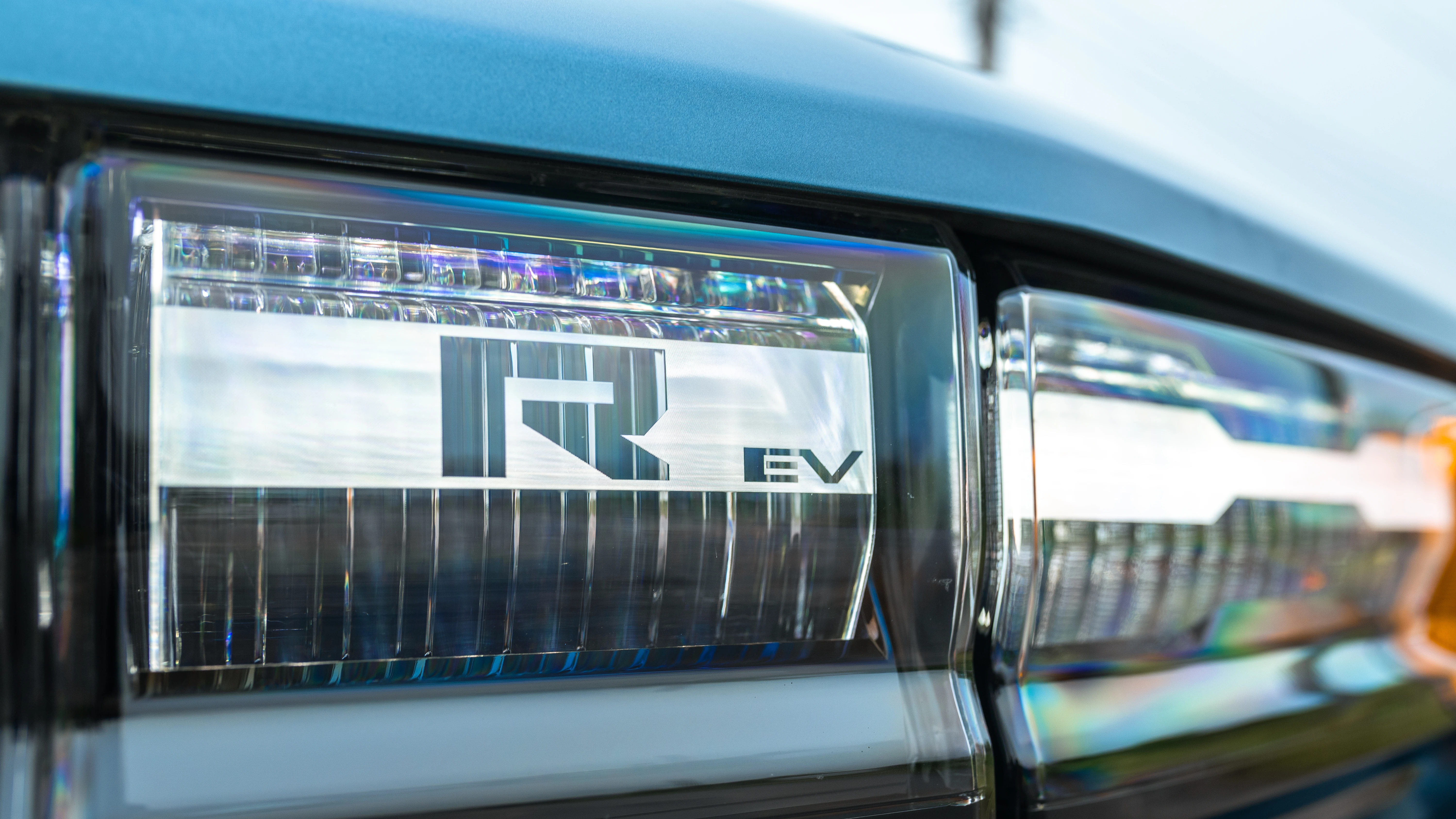 Headlight detail with the R EV motif etched into the lens
