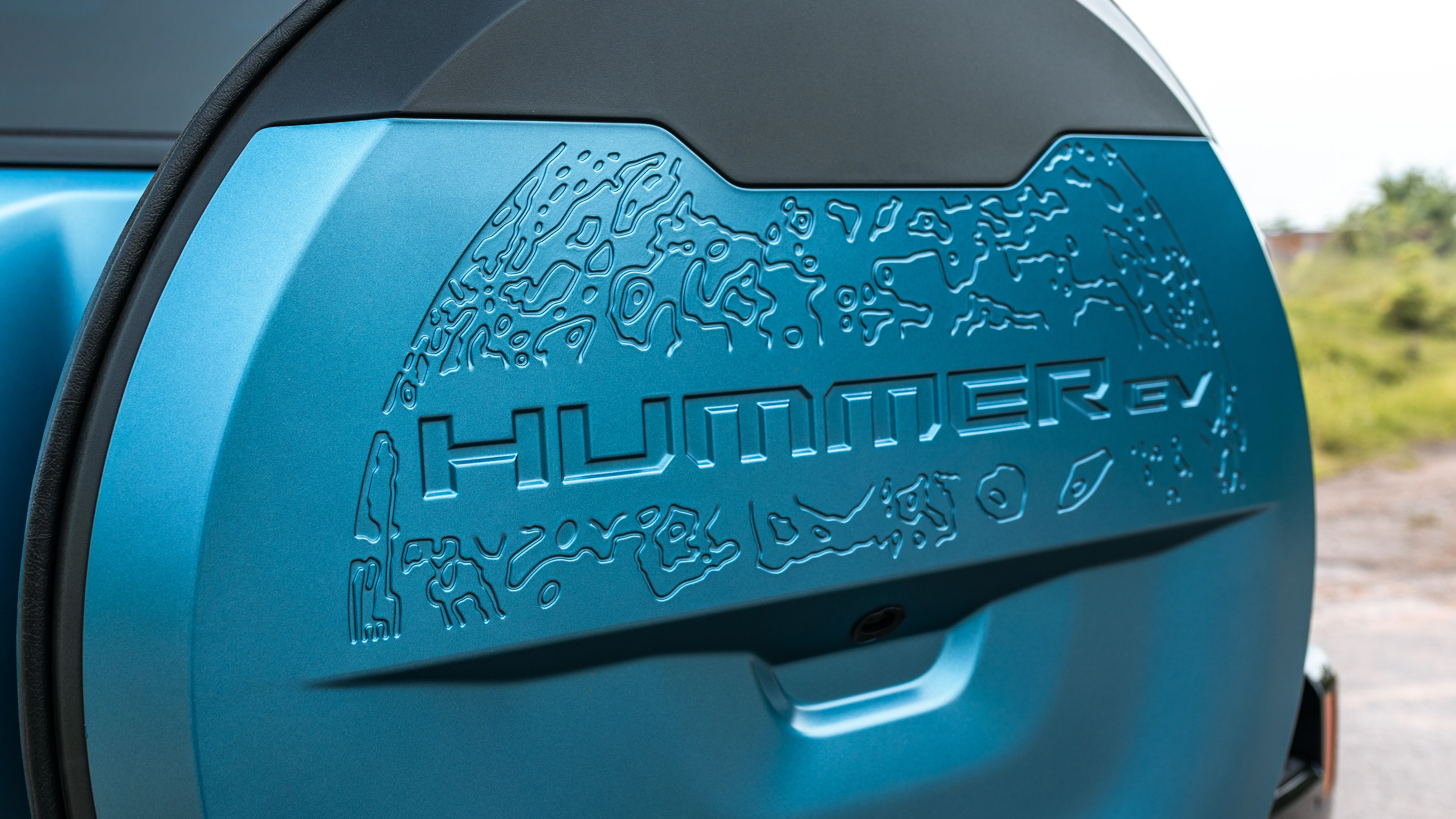 Spare tire cover embossed with HUMMER EV lettering and a lunar map