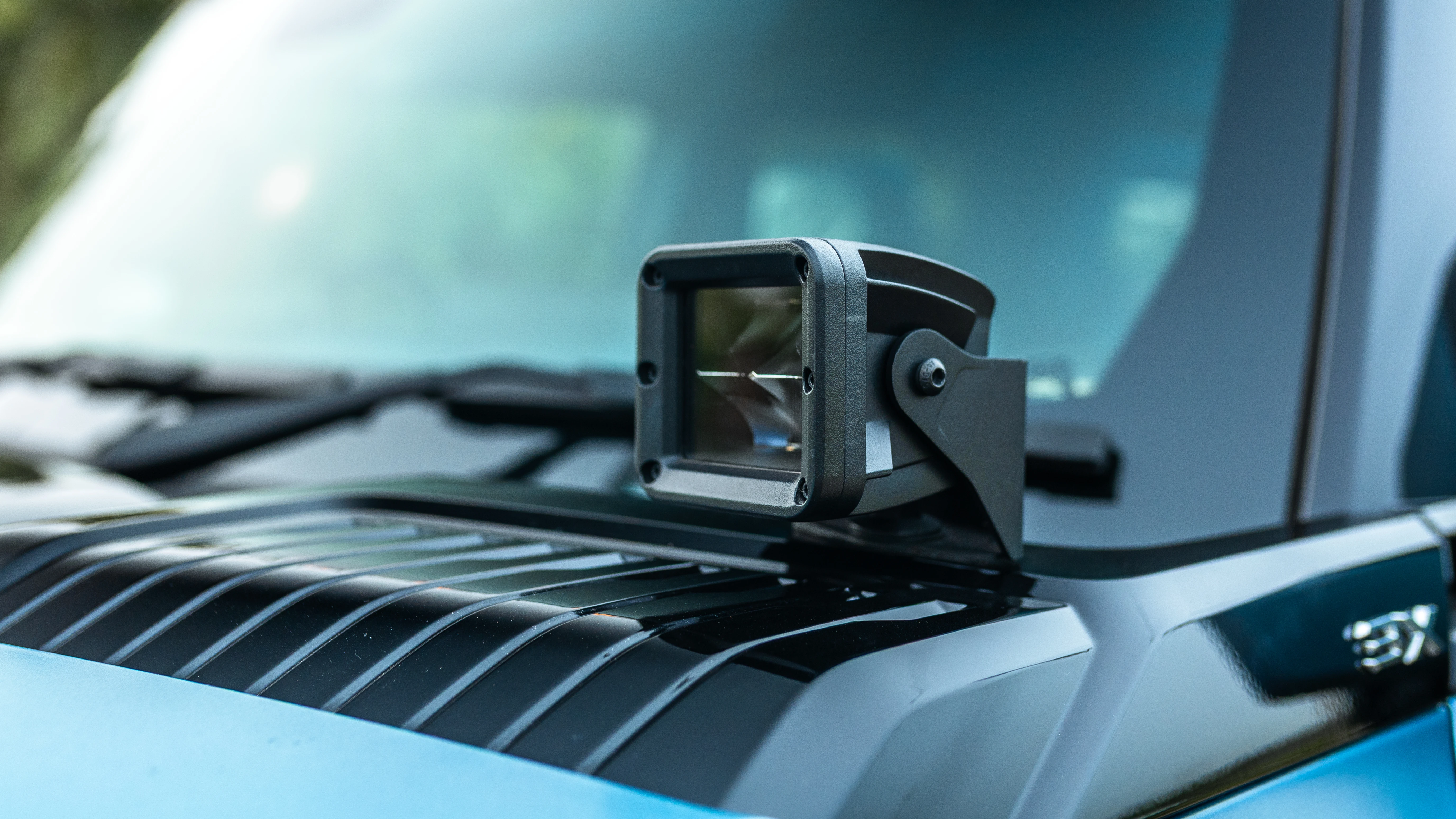 Auxiliary light pod mounted on the hood vent