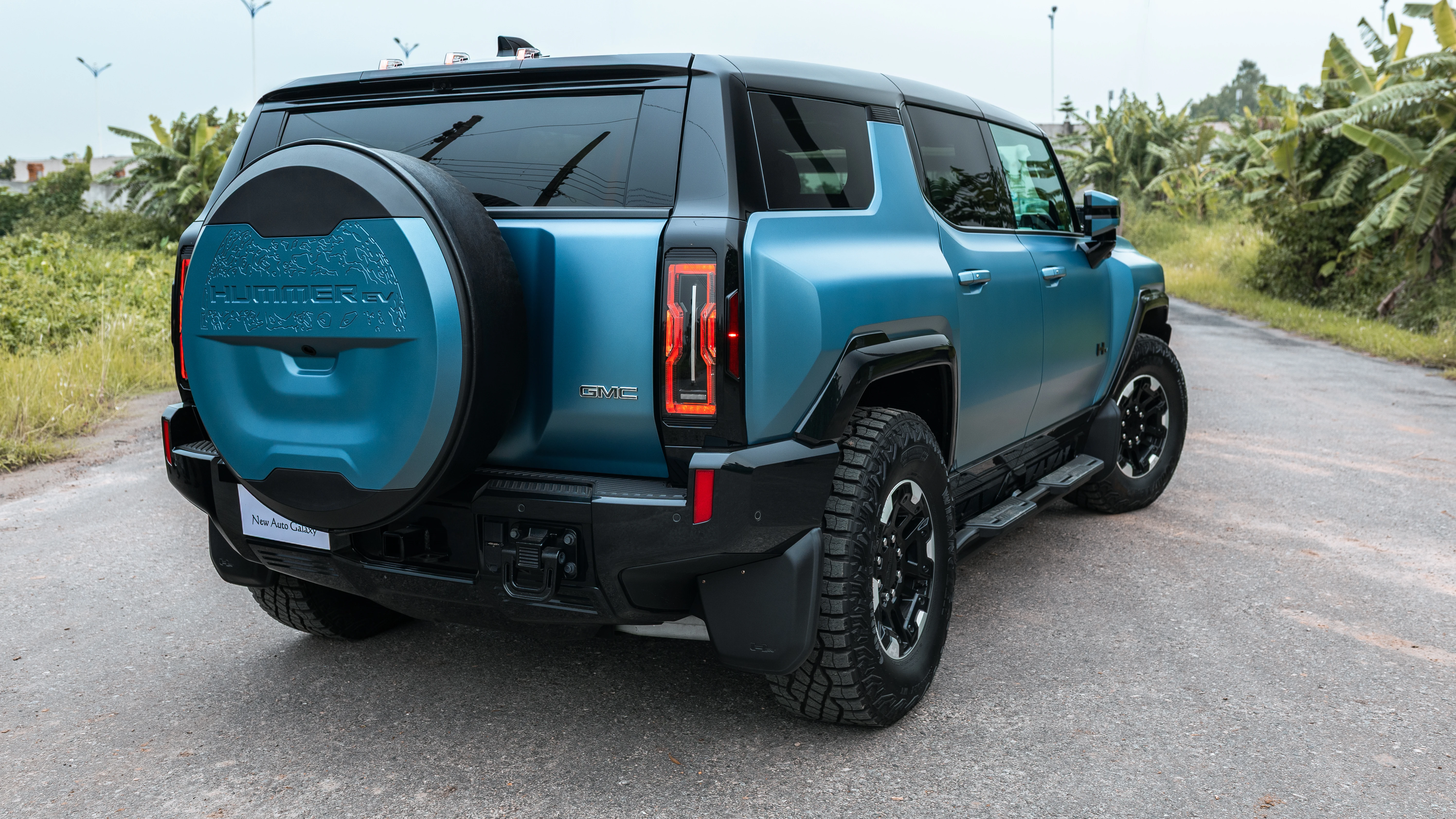 Rear three-quarter view with full-size spare and vertical taillights